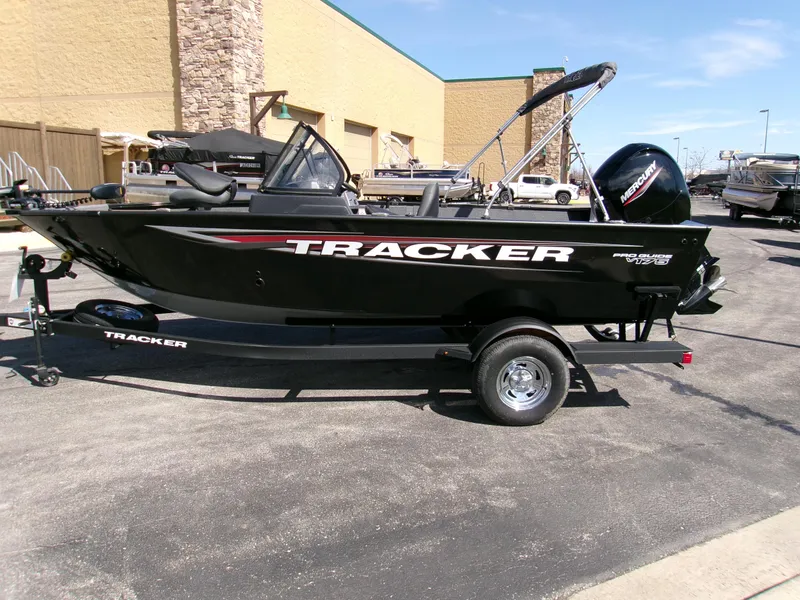 Slide: The Image of 2025 Tracker Pro Guide V-175 Combo boat on trailer, parked outdoors. - 2