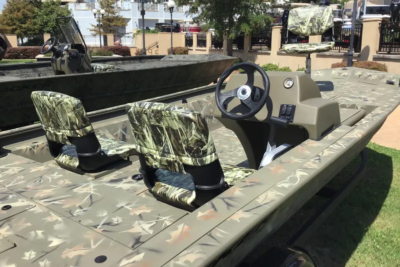Slide: The Image of 2025 Tracker Grizzly 1754 SC boat with camouflage seats and steering console. - 2