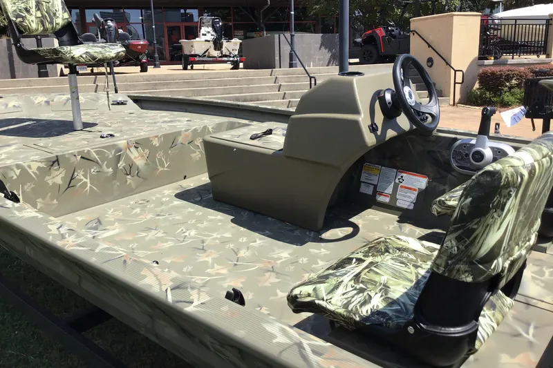 Slide: The Image of 2025 Tracker Grizzly 1754 SC boat with camouflage seating and steering console. - 3