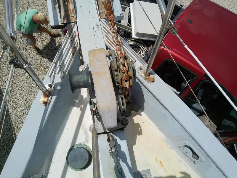 Slide: The Image of Deck view of 1978 Downeast 38 sailboat with anchor chain and nearby red vehicle. - 11