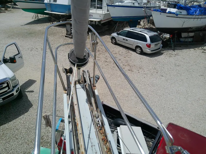 Slide: The Image of View from Downeast 38 sailboat deck, 1978 model, in a boatyard with parked vehicles. - 12
