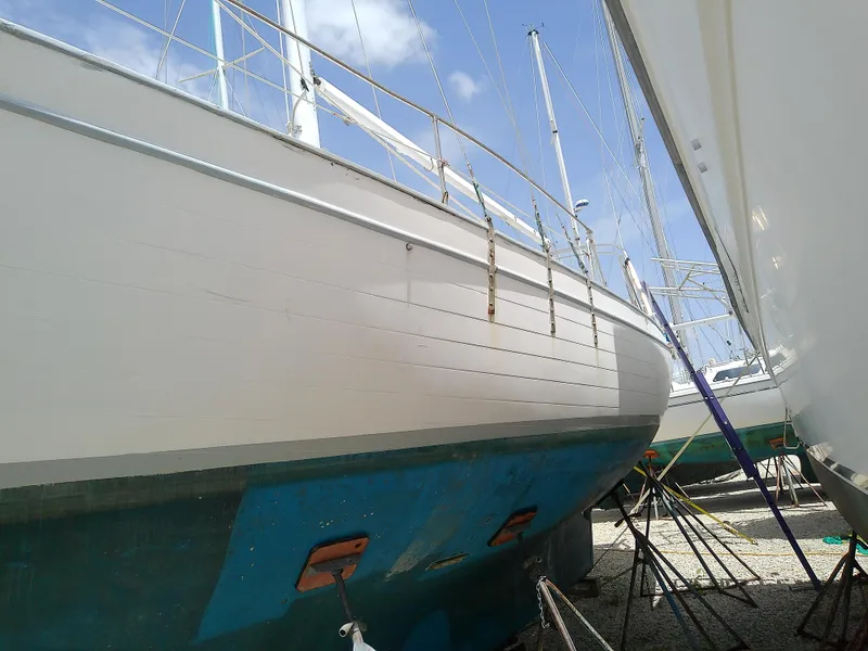 Slide: The Image of 1978 Downeast 38 sailboat on dry dock, white hull, blue bottom paint. - 3