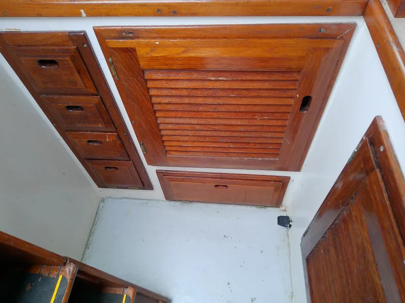 Slide: The Image of Wooden cabinetry inside a 1978 Downeast 38 boat, featuring drawers and louvered doors. - 31