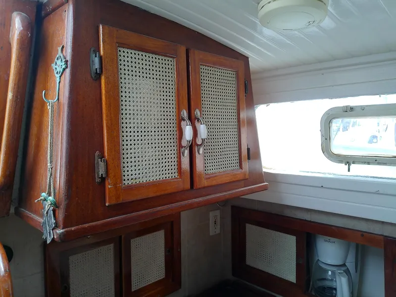 Slide: The Image of 1978 Downeast 38 interior with wooden cabinets and woven paneling. - 34