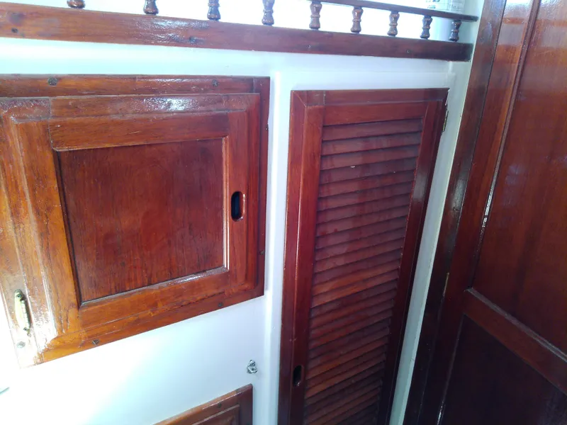 Slide: The Image of 1978 Downeast 38 interior with polished wooden cabinets and louvered door. - 45