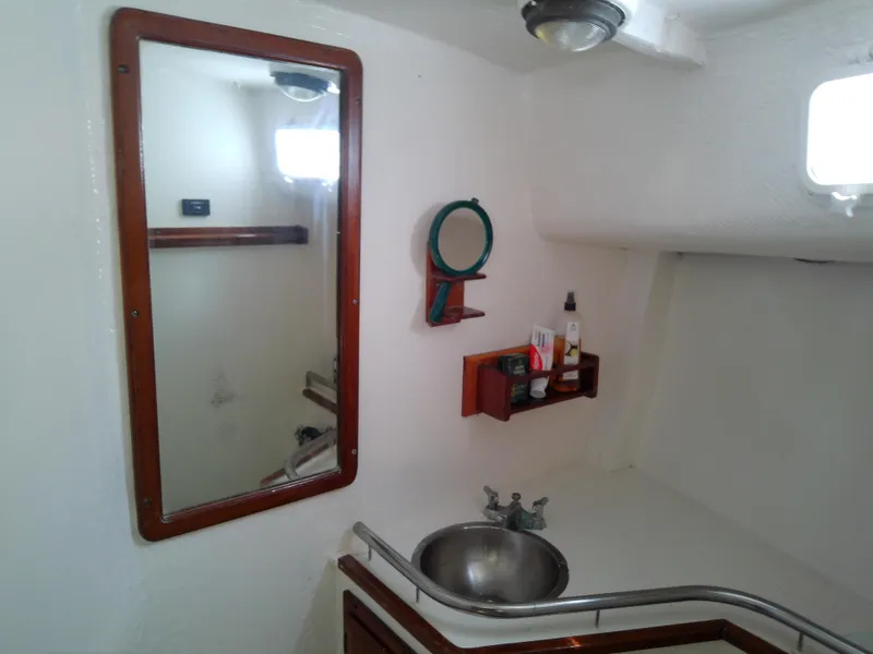 Slide: The Image of 1978 Downeast 38 yacht bathroom with mirror, sink, and storage shelves. - 48