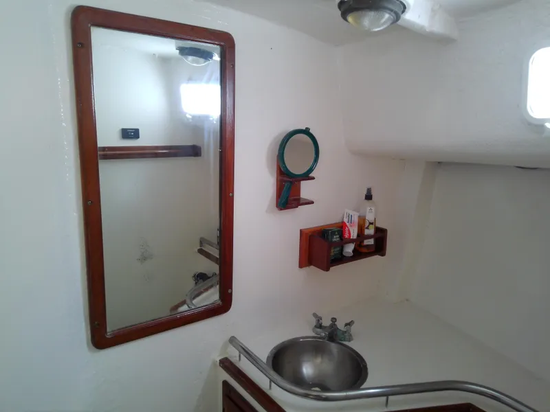 Slide: The Image of 1978 Downeast 38 yacht bathroom with mirror, sink, and storage shelves. - 49