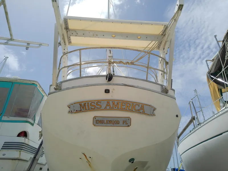 Slide: The Image of 1978 Downeast 38 boat named "Miss America" docked under a clear sky. - 5