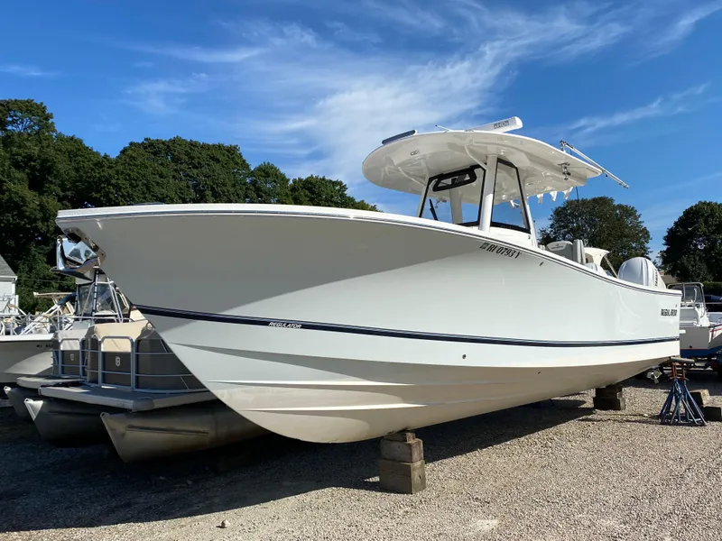 The Image of 2022 Regulator 31 boat with Yamaha engines on a stand under a clear blue sky. - 0