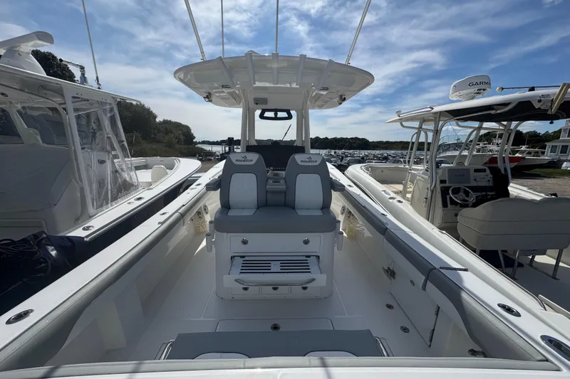 Slide: The Image of 2022 Regulator 31 boat with dual gray and white captain's chairs, armrests, and footrests. - 13