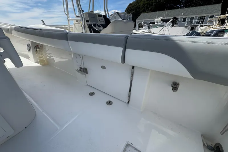 Slide: The Image of 2022 Regulator 31 boat interior with seating and helm, docked under a blue sky. - 16