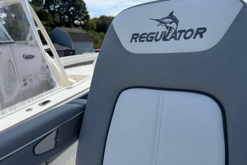 Slide: The Image of 2022 Regulator 31 boat interior with white deck and gray cushioned seating. - 19