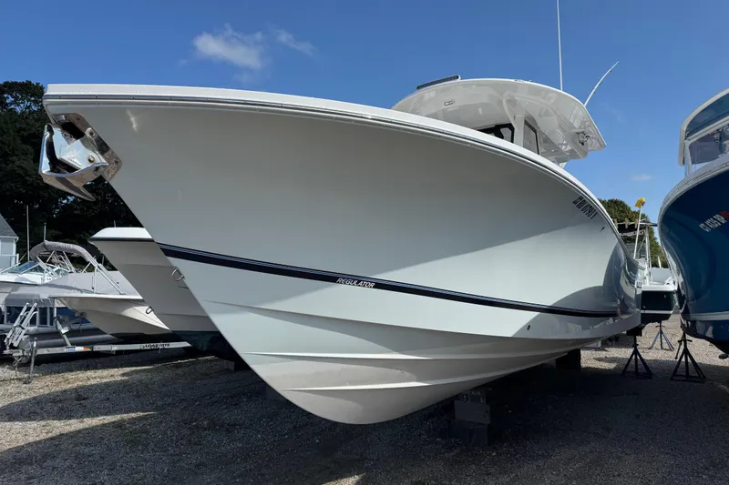 Slide: The Image of 2022 Regulator 31 boat on blocks outside marina building under blue sky. - 2