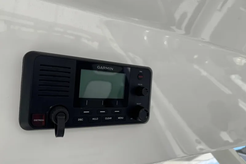 Slide: The Image of 2022 Regulator 31 boat dashboard with steering wheel and control panel, docked near a lake. - 20