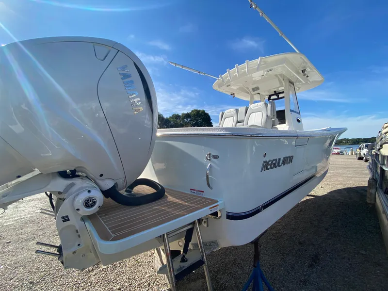 Slide: The Image of 2022 Regulator 31 boat with Yamaha outboard motor, docked under a clear blue sky. - 3