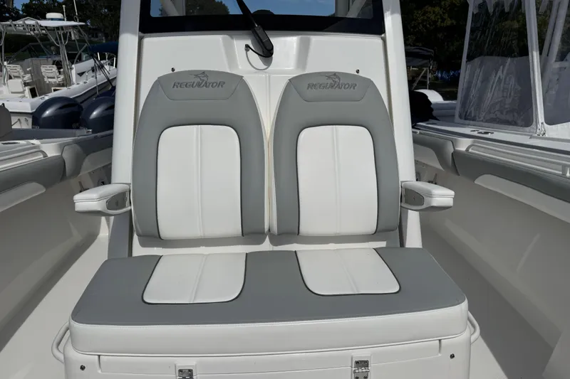 Slide: The Image of 2022 Regulator 31 boat interior with white cushioned seating and cup holders. - 8