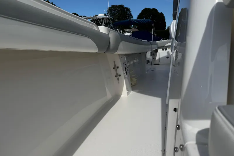 Slide: The Image of 2022 Regulator 31 boat interior with white seating and console, docked among other boats. - 9