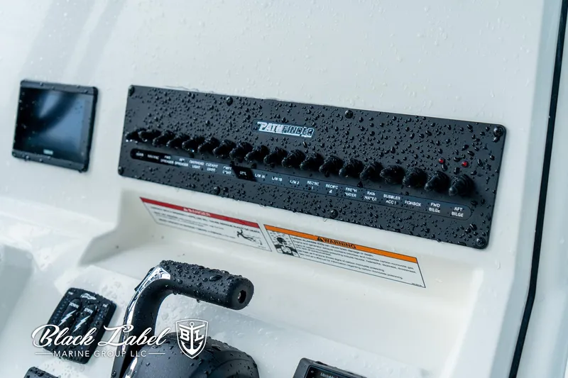 Slide: The Image of Control panel of 2025 Pathfinder Open 2400 boat, featuring switches and raindrops. - 11