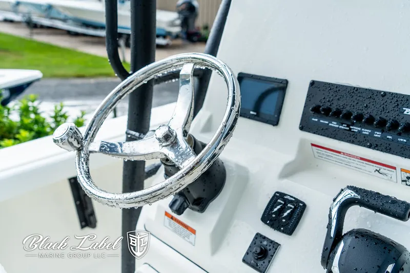 Slide: The Image of 2025 Pathfinder Open 2400 boat steering wheel and controls, wet with raindrops. - 15