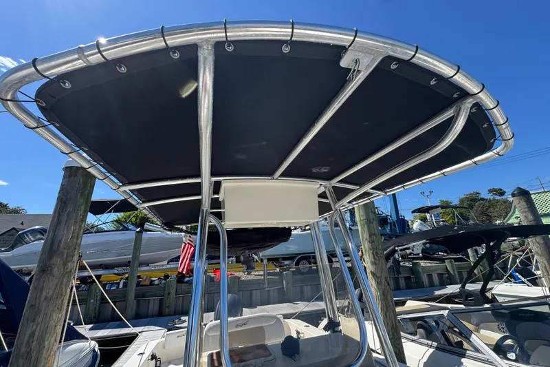 Slide: The Image of 2019 Bulls Bay 230 Center Console boat with T-top, docked under clear blue sky. - 19