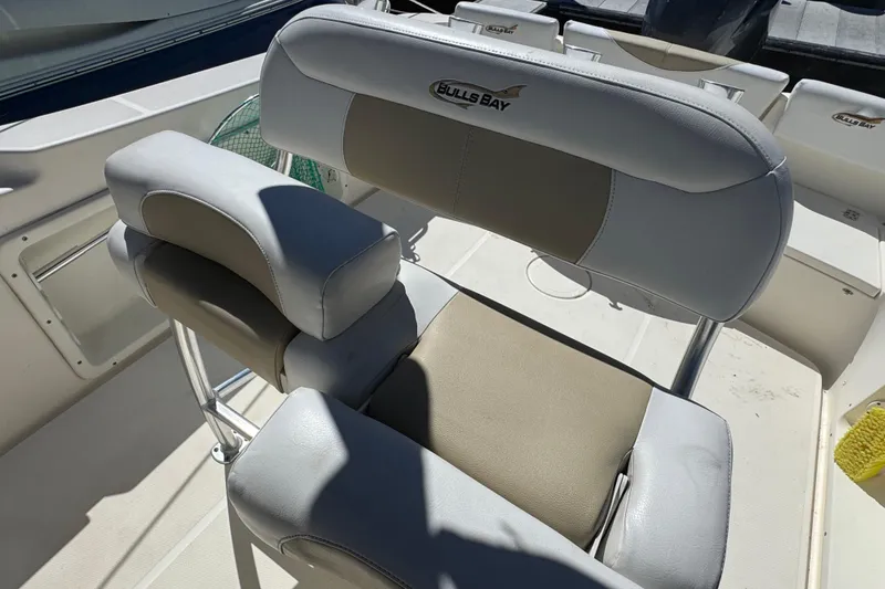 Slide: The Image of 2019 Bulls Bay 230 Center Console boat seat with cushioned backrest and armrests. - 9