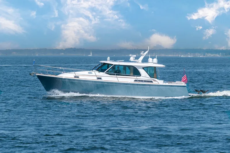 Slide: The Image of 2025 Sabre 43 Salon Express yacht cruising on open water under a clear sky. - 1