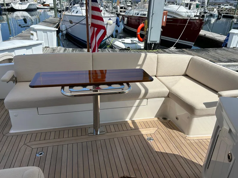 Slide: The Image of 2025 Sabre 43 Salon Express yacht with elegant seating and wooden table in marina. - 10