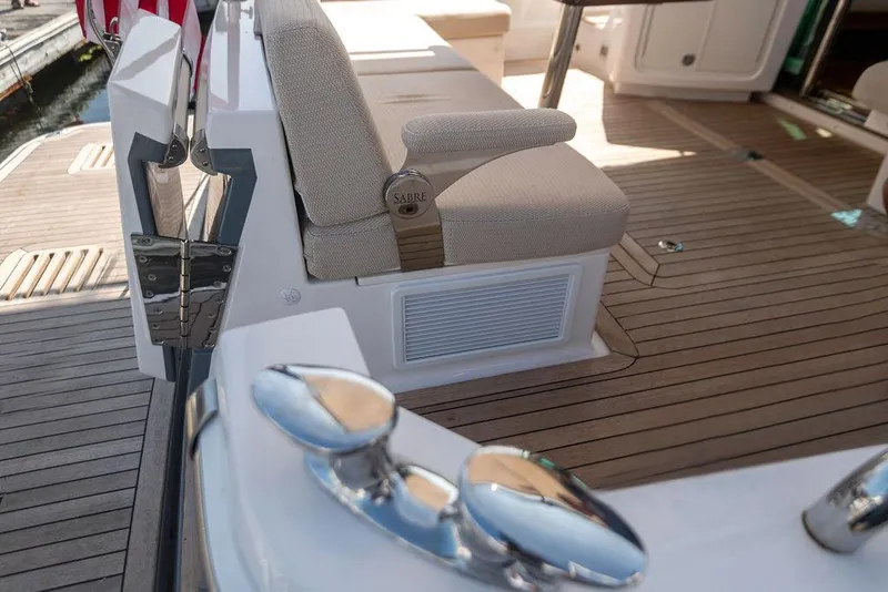 Slide: The Image of 2025 Sabre 43 Salon Express yacht deck with cushioned seating and polished fixtures. - 11