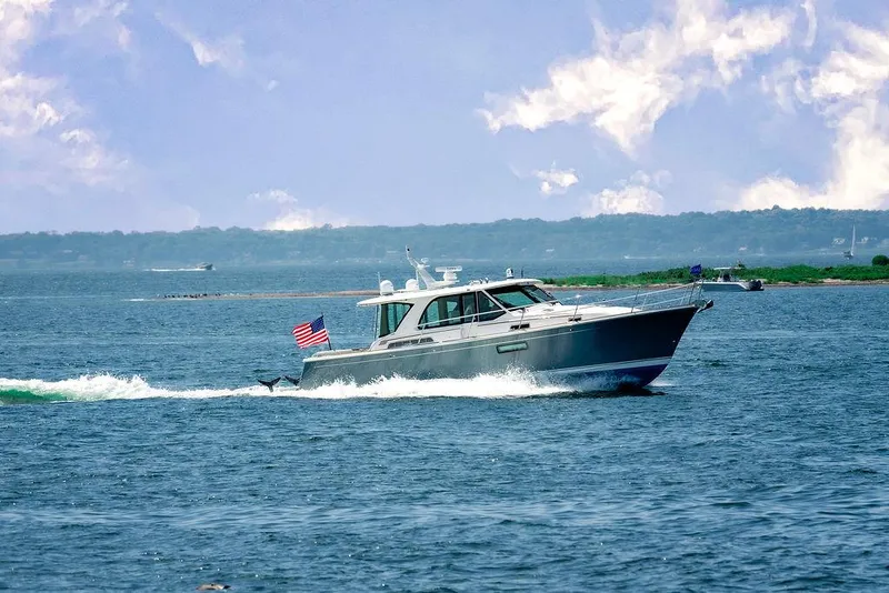 Slide: The Image of 2025 Sabre 43 Salon Express cruising on open water with American flag. - 2