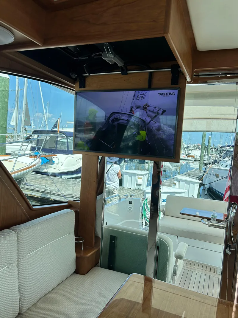 Slide: The Image of Interior of 2025 Sabre 43 Salon Express yacht with TV and marina view. - 24
