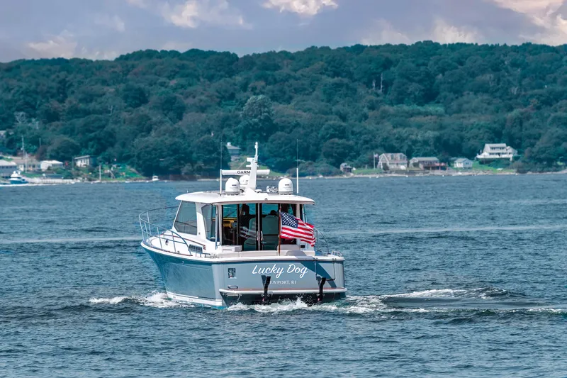 Slide: The Image of 2025 Sabre 43 Salon Express cruising on a scenic lake with forested shoreline. - 4