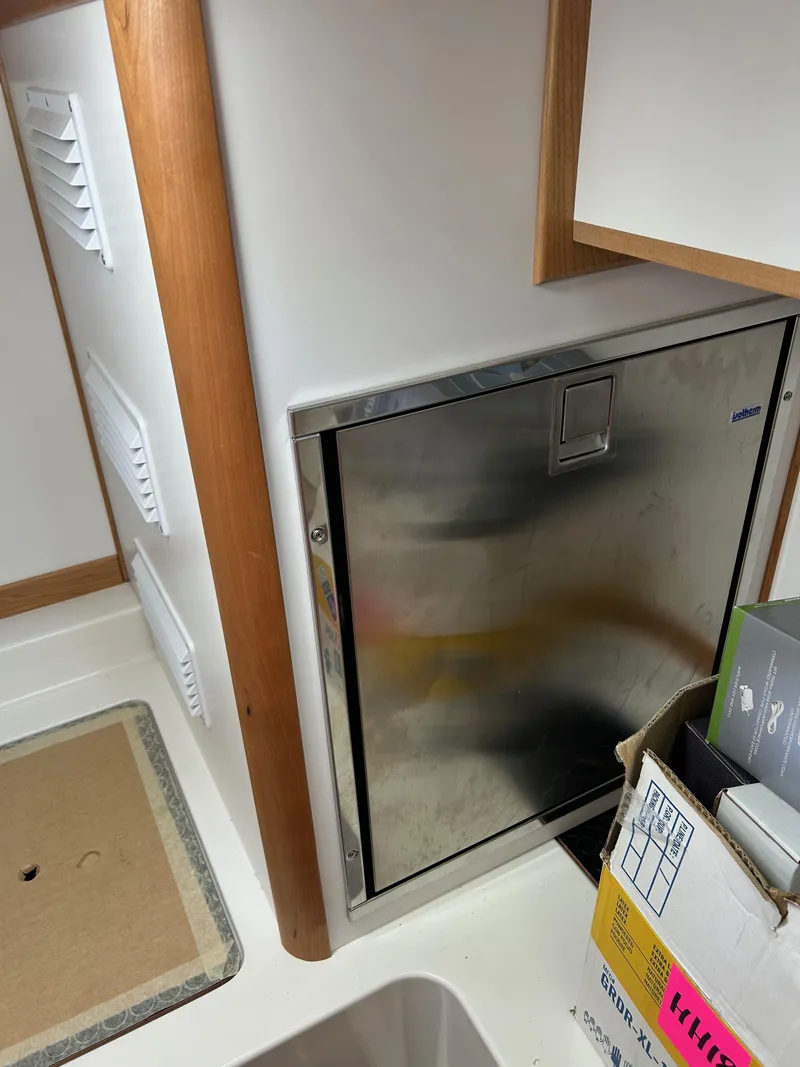 Slide: The Image of 2025 Sabre 43 Salon Express interior with stainless steel appliance and storage boxes. - 40