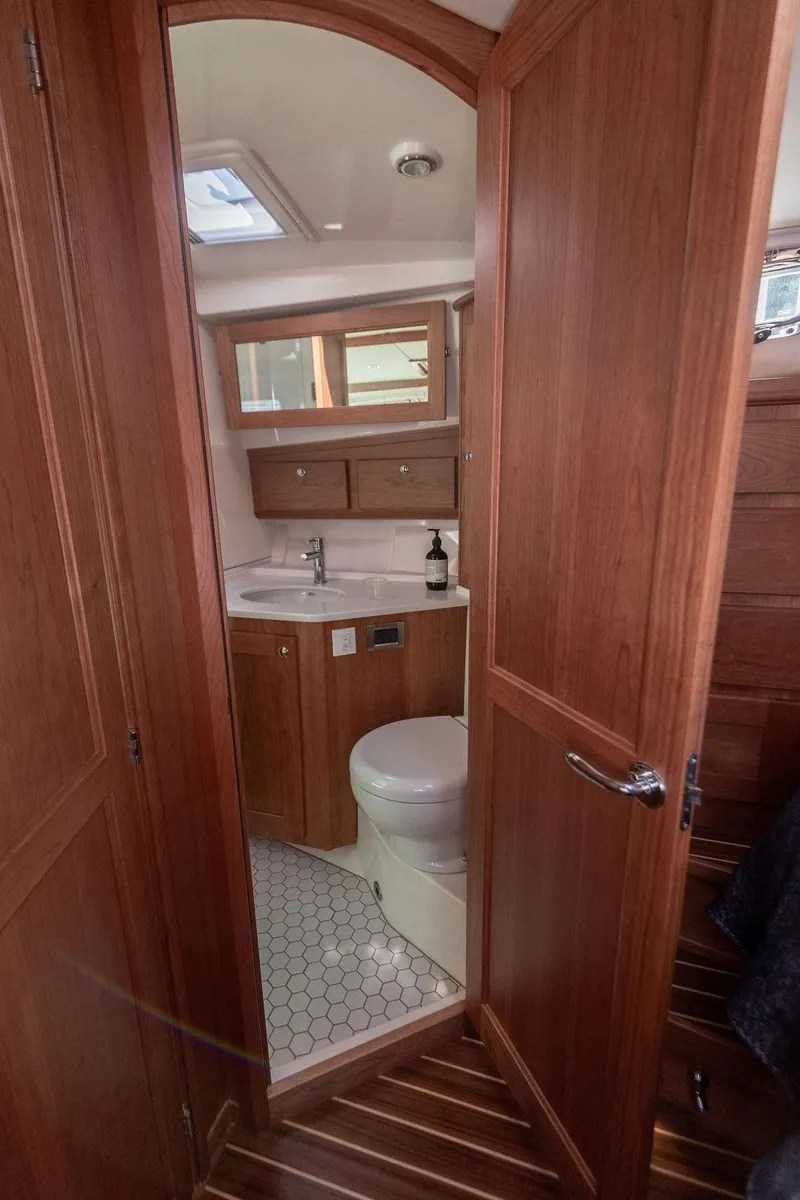 Slide: The Image of 2025 Sabre 43 Salon Express bathroom with wood cabinetry and modern fixtures. - 44