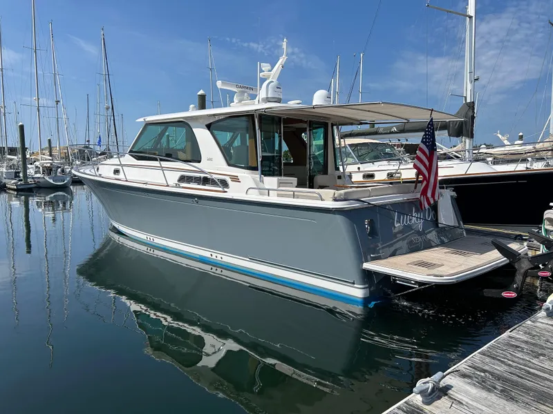 Slide: The Image of 2025 Sabre 43 Salon Express yacht docked in marina, American flag displayed. - 5