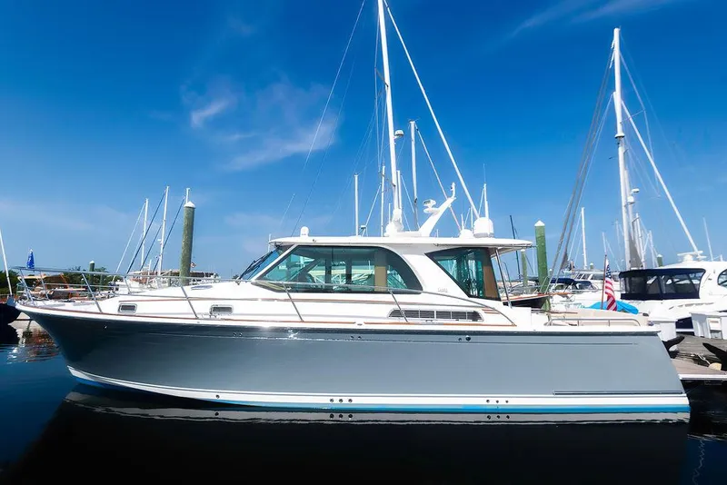 Slide: The Image of 2025 Sabre 43 Salon Express yacht docked in a marina under clear blue skies. - 6