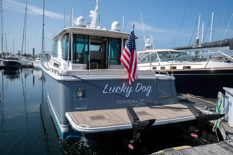 Slide: The Image of 2025 Sabre 43 Salon Express yacht docked, displaying American flag and "Lucky Dog" name. - 7
