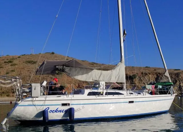Slide: The Image of Catalina 36 Mk II sailboat, 1995 model, anchored near rocky coastline. - 0