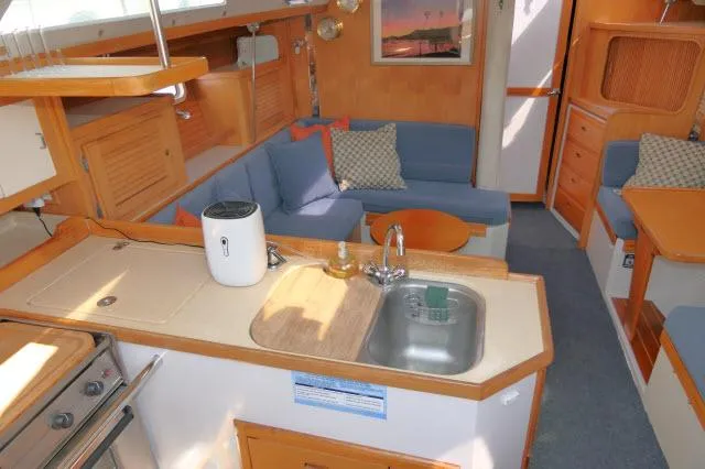 Slide: The Image of Interior of 1995 Catalina 36 Mk II sailboat with cozy seating and kitchen area. - 1