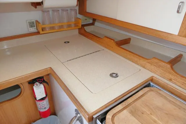 Slide: The Image of Catalina 36 Mk II 1995 yacht kitchen with countertop, fire extinguisher, and wooden accents. - 11
