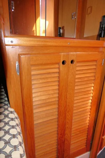 Slide: The Image of Wooden cabinet with louvered doors inside a 1995 Catalina 36 Mk II sailboat. - 19