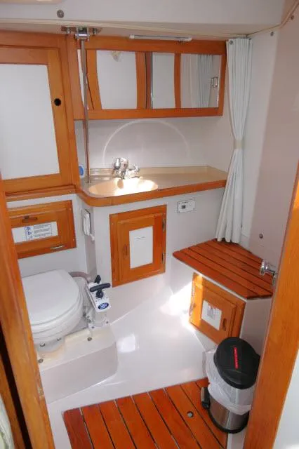 Slide: The Image of 1995 Catalina 36 Mk II yacht bathroom with wooden accents and compact design. - 23