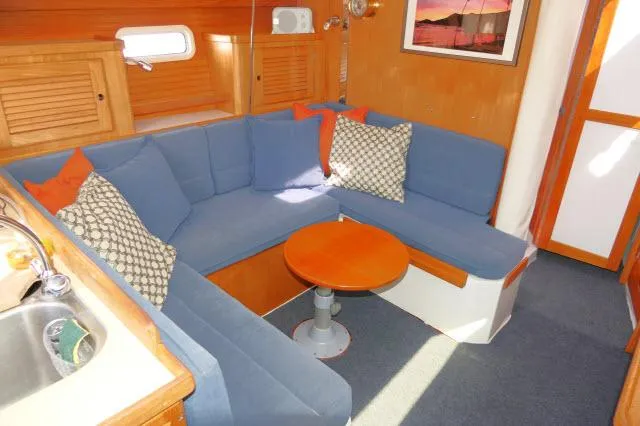 Slide: The Image of Cozy interior of 1995 Catalina 36 Mk II sailboat with blue seating and wooden accents. - 3