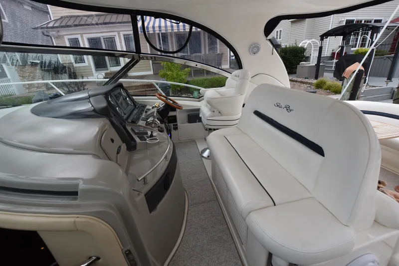 Slide: The Image of 2005 Sea Ray 420 Sundancer cockpit with white seating and modern dashboard controls. - 15