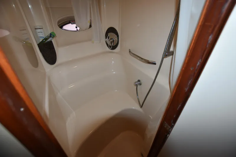 Slide: The Image of 2005 Sea Ray 420 Sundancer bathroom with shower and porthole window. - 31