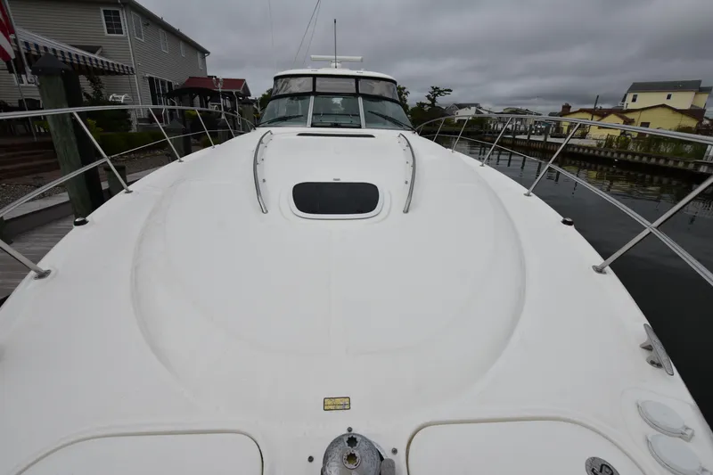 Slide: The Image of 2005 Sea Ray 420 Sundancer yacht docked, showcasing sleek design and spacious deck. - 35