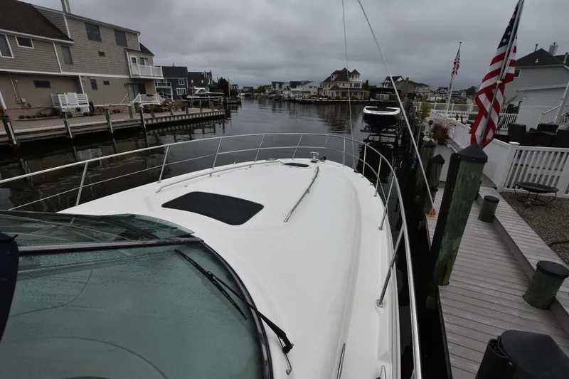 Slide: The Image of 2005 Sea Ray 420 Sundancer docked in a residential marina, overcast sky. - 36