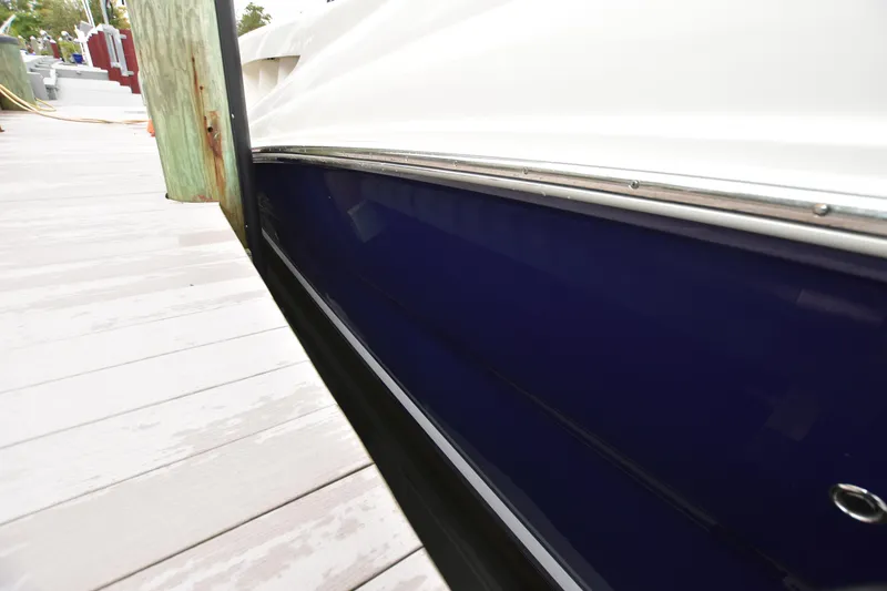 Slide: The Image of 2005 Sea Ray 420 Sundancer docked, showcasing sleek blue hull design. - 41