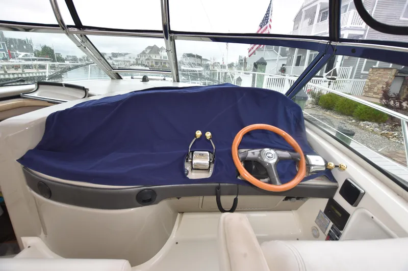 Slide: The Image of Helm of 2005 Sea Ray 420 Sundancer with covered controls and wooden steering wheel. - 47