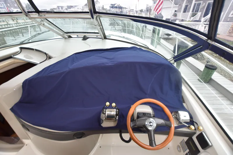 Slide: The Image of 2005 Sea Ray 420 Sundancer helm with blue cover and wooden steering wheel. - 49