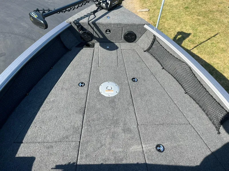 Slide: The Image of 2025 Lund 2075 Impact XS Sport boat deck with carpeted surface and storage compartments. - 18